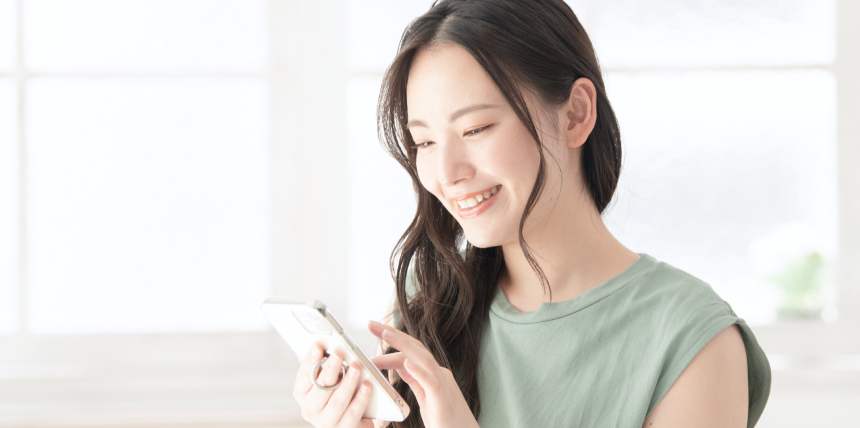 スマートフォンを操作する女性スタッフ