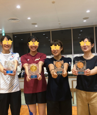 バドミントン大会で表彰盾を手にする選手たち